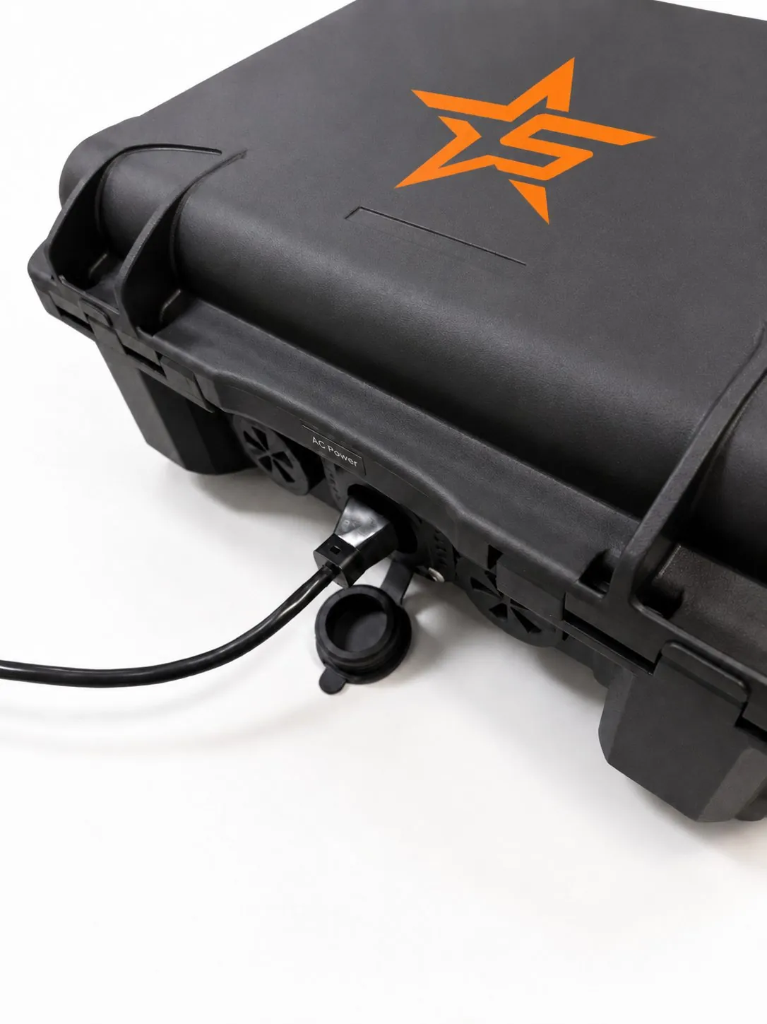 Close-up of the case's labeled AC Power inlet with a power cable plugged into the sealed panel